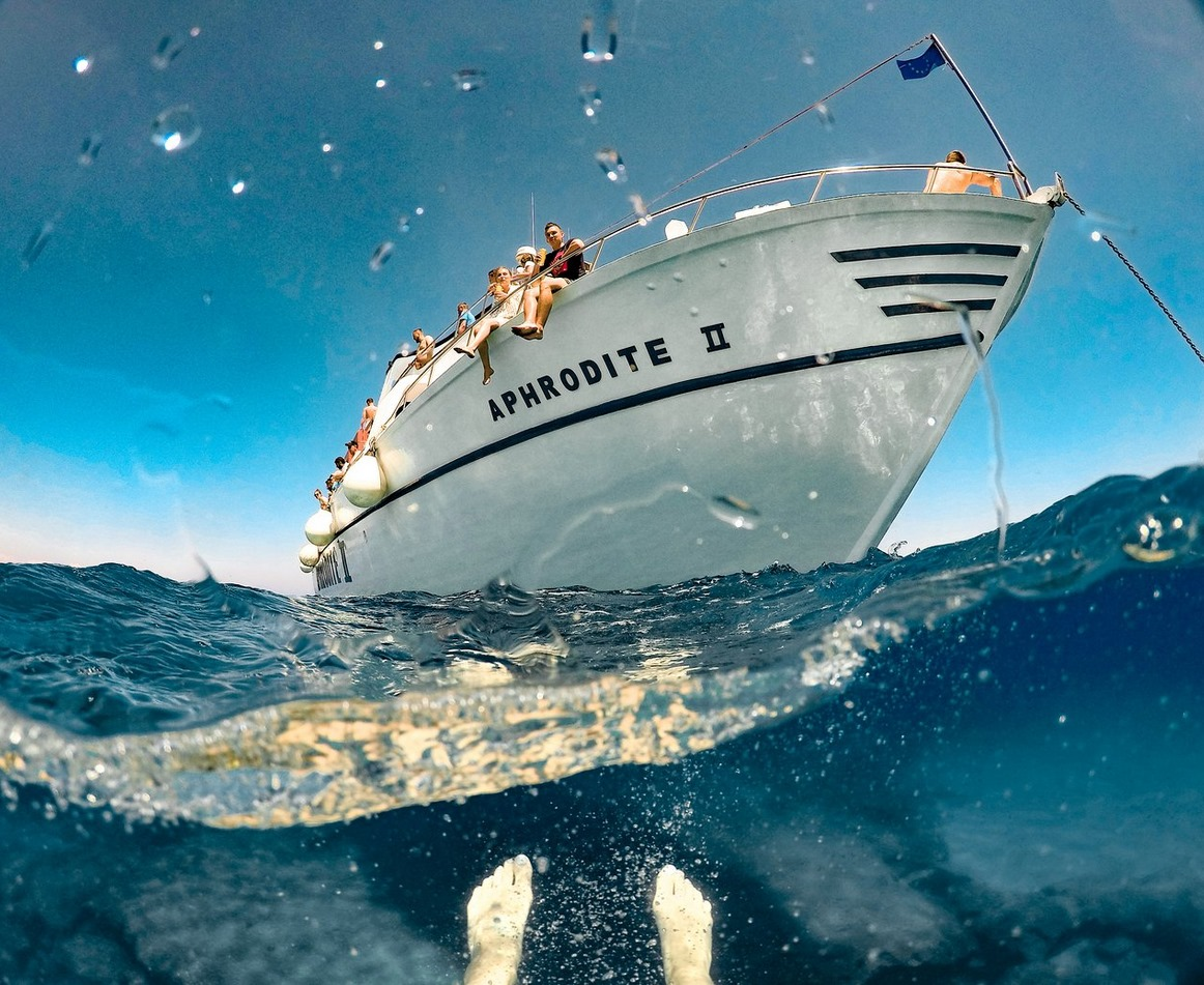 Coastal cliffs and natural arch viewed from the boat